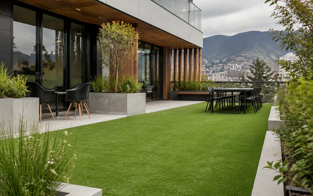 Patio exterior de oficinas con césped sintético en Quito